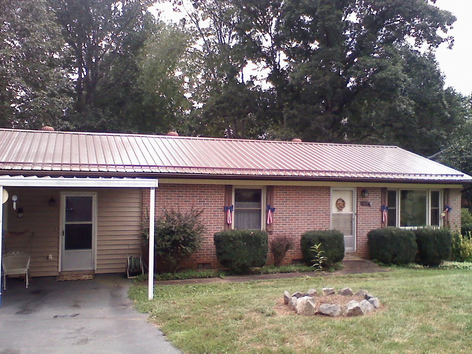 Bronze metal roof and carport on a brick ranch home — Roof Repair work by our crew in Waterboro